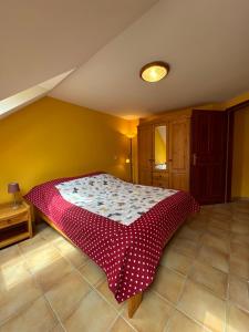 1 dormitorio con 1 cama con edredón rojo y blanco en Apartment Roman villa, en Hévíz