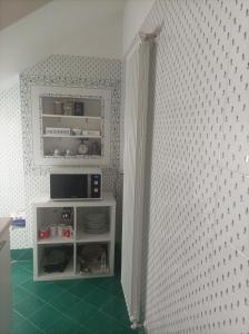 un angolo di una camera con TV e armadio di Dimora Erminia a Polignano a Mare