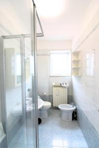 ein Bad mit einem Waschbecken, einem WC und einer Dusche in der Unterkunft Holiday in Caorle
