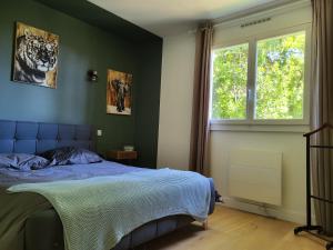 ein Schlafzimmer mit einem blauen Bett und einem Fenster in der Unterkunft Appartement Résidence Villeneuve in Villeneuve-lès-Avignon