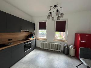 una cucina con armadi neri e frigorifero rosso di LiFarm ad Aerzen