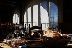 - une table avec un panier de pain et des verres à vin dans l'établissement Santuari de Santa Maria de Montgrony, à Gombreny