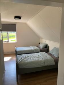een slaapkamer met 2 bedden op een zolder bij De Steerne, mooie plek aan het Overijssels kanaal. in Schalkhaar