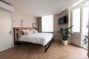 Un dormitorio con una cama grande y una maceta en Stadsherberg de Poshoorn en Maastricht