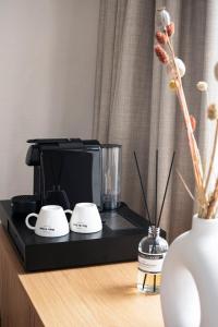 a black coffee maker sitting on a wooden table at Stadsherberg de Poshoorn in Maastricht