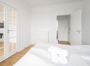 a white bedroom with white walls and a bed with two pillows at 2-BR apartment with a balcony in Charlottenlund - 192 in Charlottenlund +2 photos