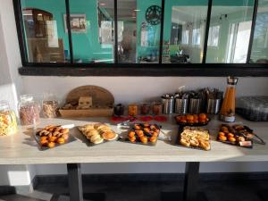 - une table avec de nombreux types de pain et de viennoiseries dans l'établissement Hotel Mas des Lys, à Saintes-Maries-de-la-Mer