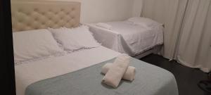 um quarto com duas camas com uma toalha na cama em ALOJATE CATALEIA dep 1 EZEIZA PLENO CENTRO A 12 MINUTOS DE AEROPUERTO MINISTRO PISTARINI em Ezeiza