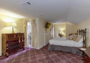 a bedroom with a large white bed and a window at The Inn at Cedar Grove in Vicksburg