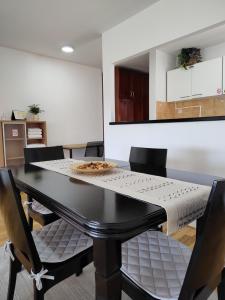 comedor con mesa negra y sillas en Apartman Visnjica, en Rospi Ćuprija