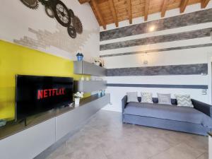 sala de estar con sofá y TV en Pool relax - Castelnuovo del garda - Garda Lake - Private Parking, en Sandra