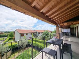 patio con mesa y sillas en el balcón en Pool relax - Castelnuovo del garda - Garda Lake - Private Parking, en Sandra