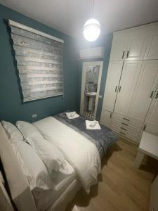 a bedroom with a large bed and a blue wall at Vila Emre in Korçë