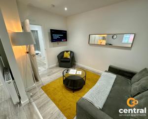 un soggiorno con divano e tavolo di 2 Bedroom Apartment by Central Serviced Apartments - Seagate - Close City Centre or Universities - Sleeps 4 1 x Double 2 x Single - Short Term Stays Welcome - Walk away from Train & Bus Station - Bus Routes to all over Dundee close by a Dundee