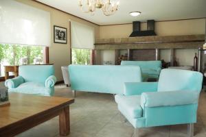 a living room with blue chairs and a table at Sent Calafate in El Calafate