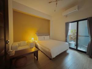 台東市的住宿－飛行船電梯民宿，一间卧室配有一张床、一张书桌和一个窗户。