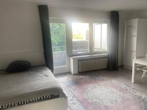 a bedroom with a bed and a large window at Gemütliches Zuhause in 1A Lage in Herne