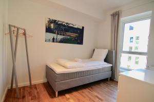 コペンハーゲンにあるFantastic 2-bed w balcony in Ørestadenのベッドと窓が備わる小さな客室です。