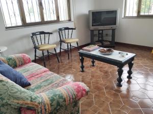 sala de estar con sofá, mesa y TV en Villa Rica House, en Negreira