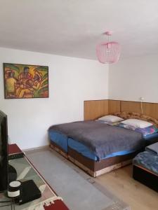 a bedroom with a bed and a chandelier at Lesný domček in Hunisky