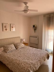 ein Schlafzimmer mit einem Bett und einem Deckenventilator in der Unterkunft Apartamento San Vicente in Villar del Arzobispo