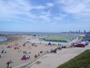 un grupo de personas en una playa cerca del océano en Alquiler Temporada Casa 2 dormitorios para 6 personas en Mar del Plata