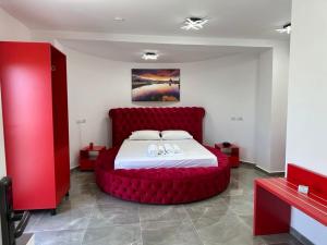 ein Schlafzimmer mit einem großen roten Bett in einem Zimmer in der Unterkunft Vullkan Hotel in Ksamil