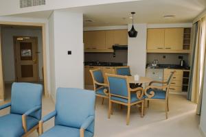 eine Küche und ein Esszimmer mit einem Tisch und Stühlen in der Unterkunft Sheraton Khalidiya Hotel in Abu Dhabi