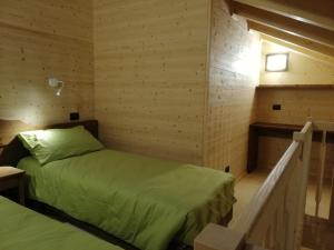 een kamer met 2 bedden in een kamer met houten wanden bij Agriturismo Le Rocher Fleuri in Bard