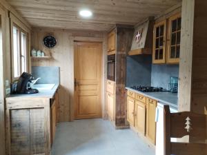 a kitchen with wooden cabinets and a counter top at Petit Chalet in Essert-Romand