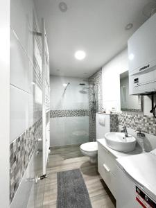 a white bathroom with a toilet and a sink at Studio apartman Medvedgrad in Zagreb