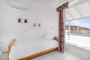 a bedroom with a bed and a large window at Villa Asossa with Private pool & Sea view in Dhaskalión