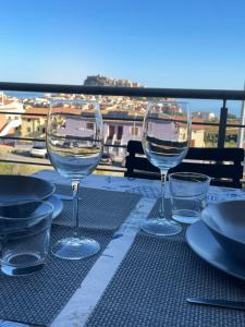 three wine glasses sitting on top of a table at Appartamento Il Tramonto in Castelsardo