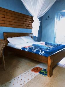 uma cama num quarto com uma parede azul em Vineyard Retreat Voi em Voi