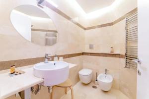 bagno con lavandino, servizi igienici e specchio di Home 33 a Napoli