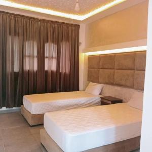 um quarto de hotel com duas camas e uma janela em camping atlantique tan tan em Tan-Tan Plage
