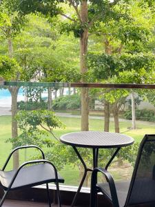 a table and two chairs in front of a window at Ezyhouz Homestay #The Loft Imago City #Luxury Pool Garden View in Kota Kinabalu