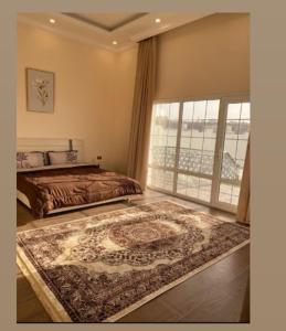 a bedroom with a bed and a rug on the floor at Alrabe3 شاليه 