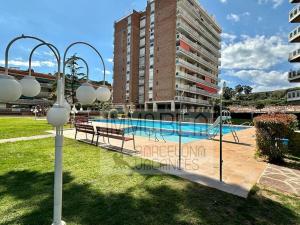 a swimming pool with two benches and a building at BV-SV-002-Mediterrani in Sant Andreu de Llavaneres
