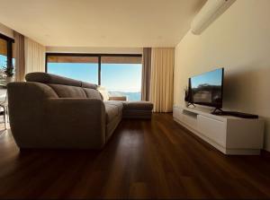 a living room with a couch and a flat screen tv at Encosta do Gerês Village in Ventosa