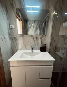 a bathroom with a white sink and a mirror at Encosta do Gerês Village in Braga