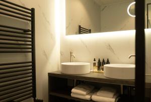 a bathroom with two sinks and a mirror at Hotel New York by WestCord in Rotterdam +40 photos