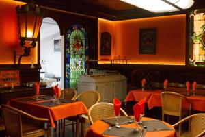 a dining room with tables and a stained glass window at Hotel Fortin in Anost