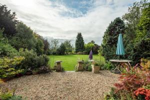 a garden with an umbrella and a table and chairs at Charming Georgian Country House in Axbridge