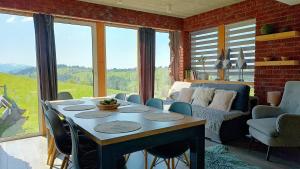 a room with a table and chairs and a couch at Lux Houses DOMEK z widokiem na Tatry z prywatnym jacuzzi in Gliczarów