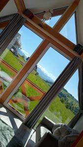 a room with a large window with a view of a mountain at Lux Houses DOMEK z widokiem na Tatry z prywatnym jacuzzi in Gliczarów