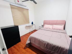 a bedroom with a large bed and a dresser and avertisement at D'Camellia Ecohill Homestay in Semenyih +12 photos