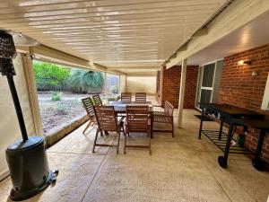 a patio with a table and chairs and a ping pong table at Three bears beach house in Dunsborough
