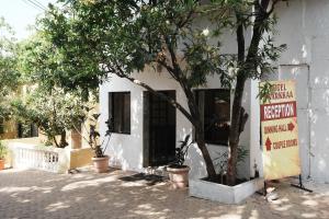 a white building with a tree in front of it at Dwarka Lawns Cottages in Mahabaleshwar +40 photos