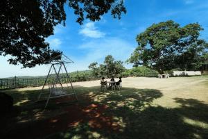 two people sitting at a table in a park at Dwarka Lawns Cottages in Mahabaleshwar